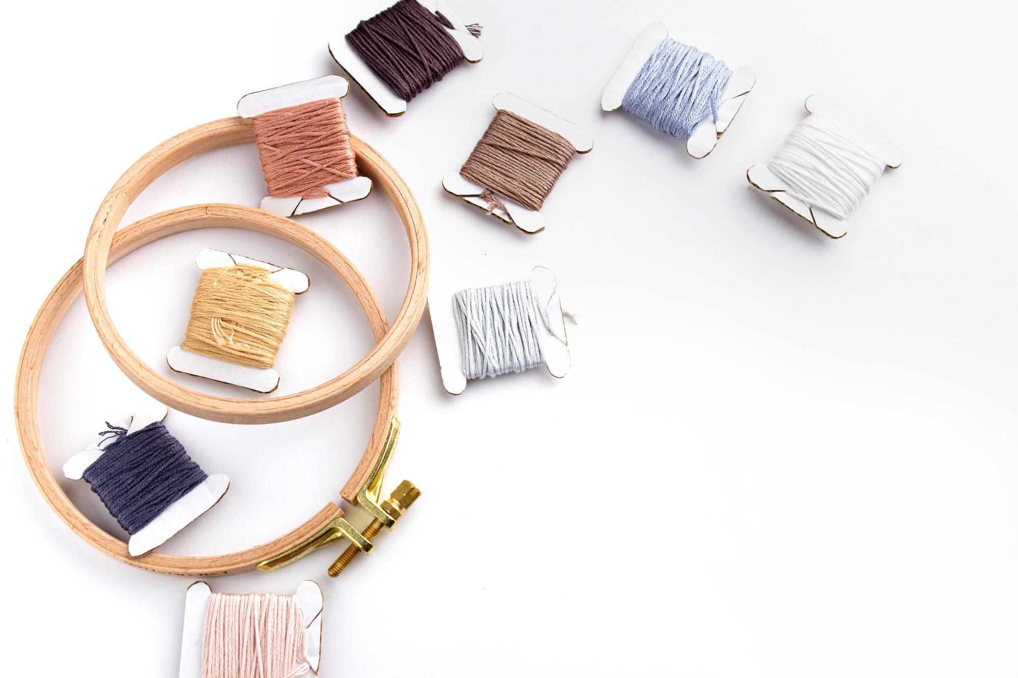 Studio table with threads and stitched samples